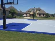 Full size basketball court with acrylic surfacing in bright blue and grey
